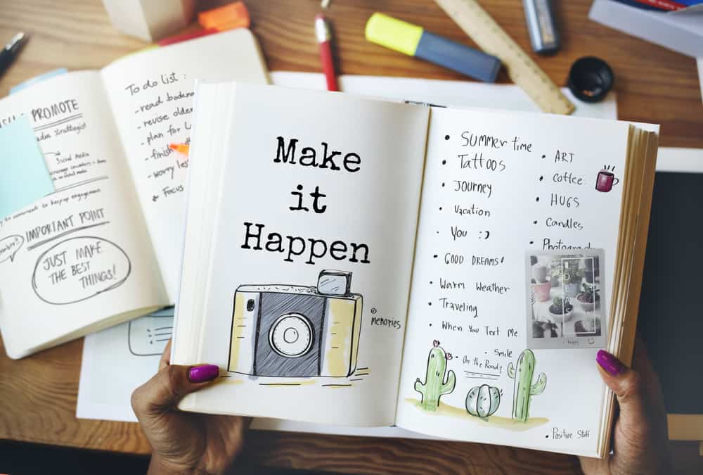 A journal is opened and on the inside are illustrations and it says "Make it happen."